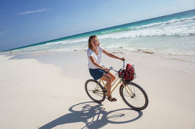 Woman riding bicycle on beach