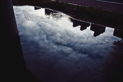 Reflection of cloudy sky in puddle