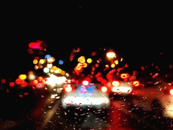 Defocused image of illuminated wet road at night