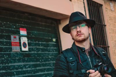 Portrait of man standing against wall