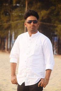 Portrait of young man standing at beach