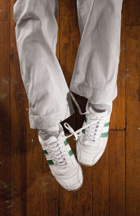 Low section of man standing on hardwood floor