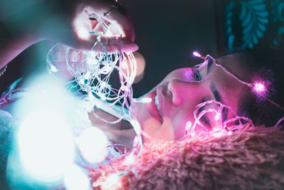 Portrait of happy woman with illuminated light painting at night