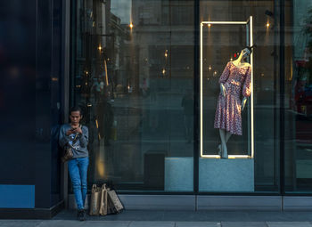 People in illuminated glass window