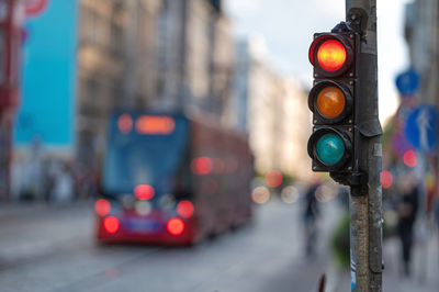 Blurred view of city traffic with traffic lights, in the foreground a semaphore with a red light