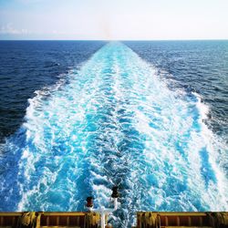 Scenic view of wake water in sea against sky