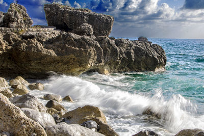 Scenic view of rocks in sea against sky