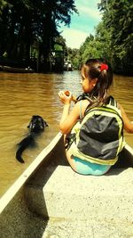 Side view of girl playing with horse in water