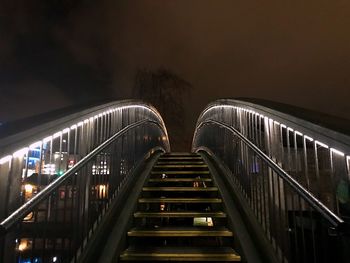 Illuminated staircase in city against sky at night