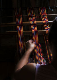 High angle view of woman weaving at workshop