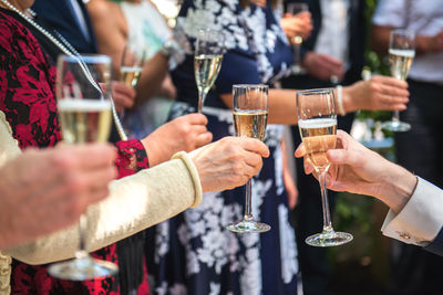 Cropped hands of friends toasting champagne flutes in party