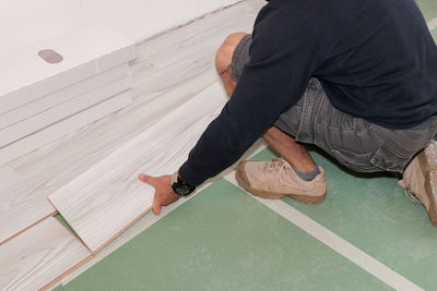 Low section of man playing with ball on floor