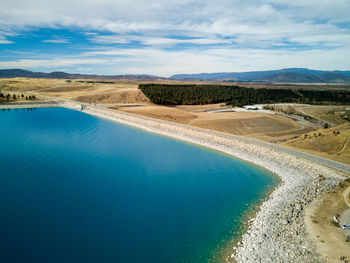 Scenic view of swimming pool by lake against sky