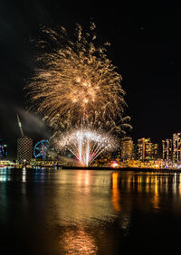 Firework display over river at night