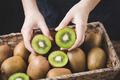 Midsection of person holding kiwis