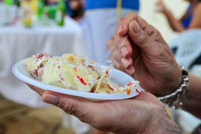 Close-up of person holding cake in plate