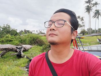 Portrait of young man wearing sunglasses against sky