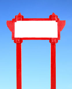 Low angle view of telephone pole against clear blue sky