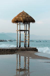 Lifeguard hut on beach against sky