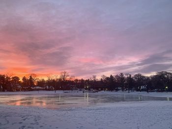 Scenic view of frozen lake against sky during sunset