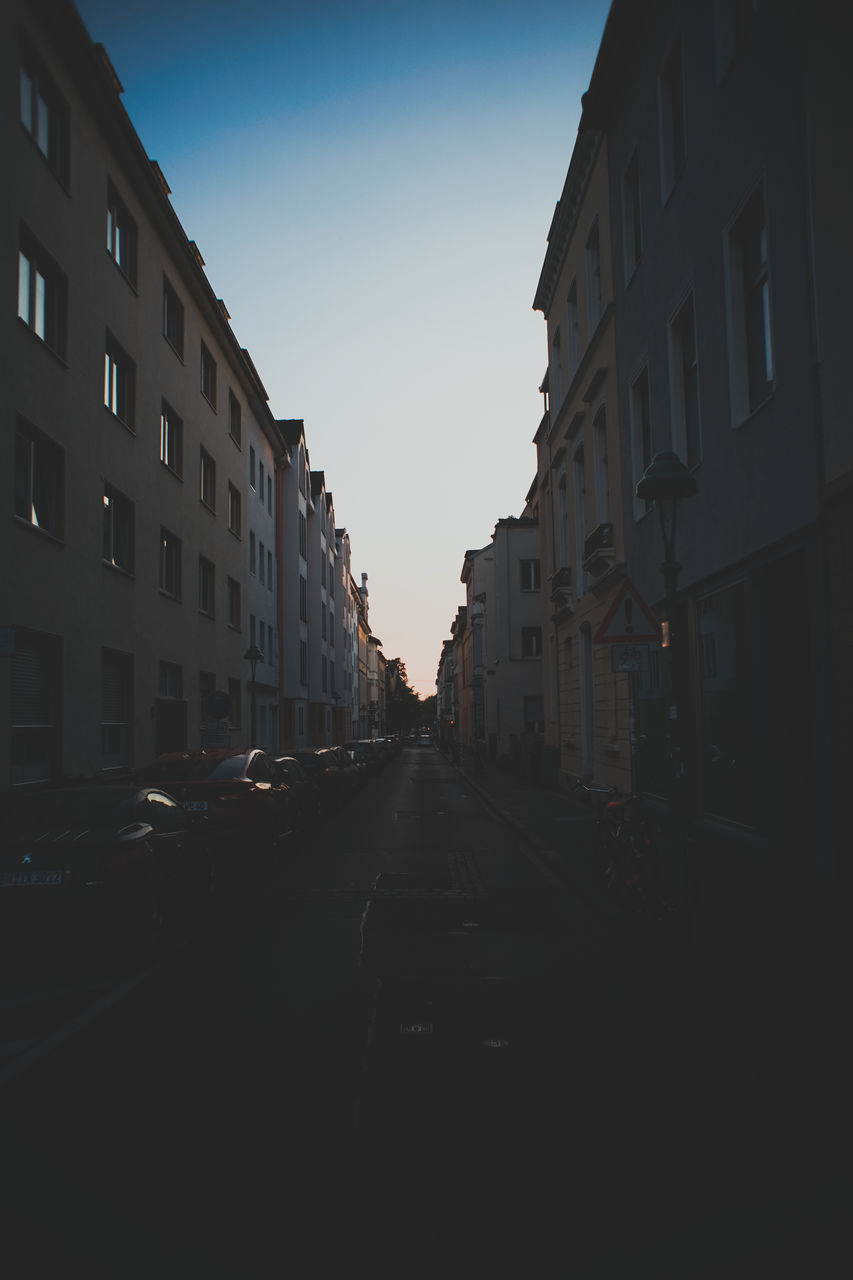 CITY STREET AMIDST BUILDINGS AGAINST SKY