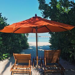 Empty chairs and tables against clear sky