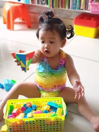 Portrait of cute girl sitting with toys