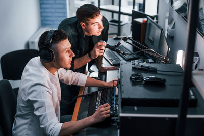 Conception of teamwork. two guys is indoors in the radio studio is busy by broadcast.