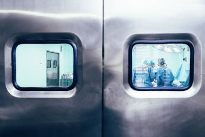 Doctors in operation theater seen through glass