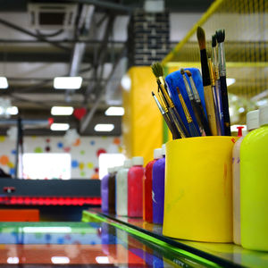 Close-up of paint and brushes on table