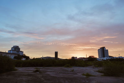 Buildings in city against sky during sunset