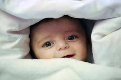 Portrait of cute baby lying on bed