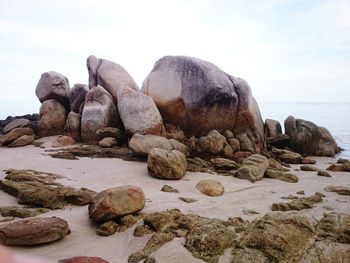 Rocks on beach against sky