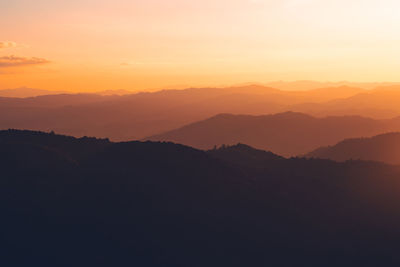 Scenic view of silhouette mountains against sky at sunset