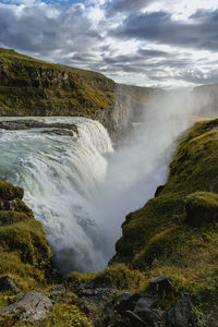 Scenic view of waterfall against sky