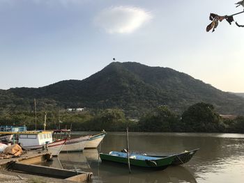 Sailboats moored on lake against sky