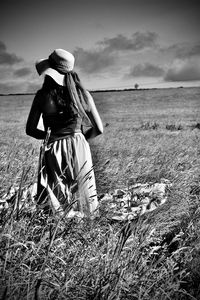 Rear view of woman on field against sky