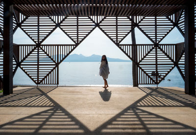 Rear view of woman standing on bridge