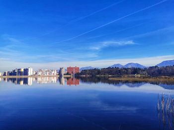 Reflection of building in lake against blue sky