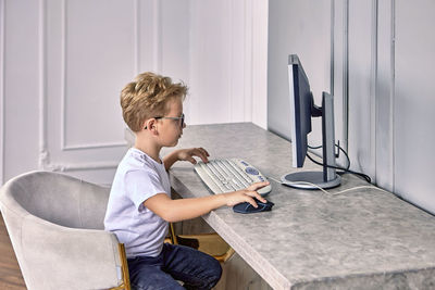 Side view of boy playing game at home