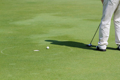 Low section of man playing golf on course