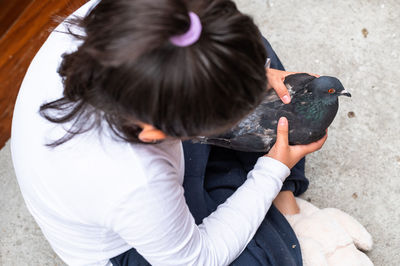 High angle view of girl holding bird