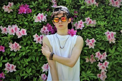 Low section of person standing by pink flowering plants