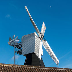 Low angle view of traditional windmill against clear blue sky