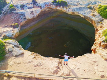 Man standing on rock formation in water