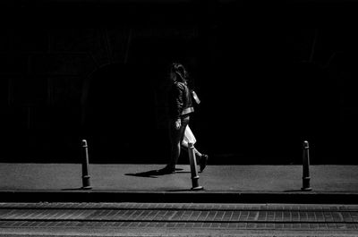 Woman walking on footpath in city