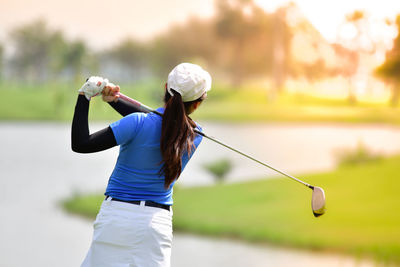 Rear view of woman playing golf