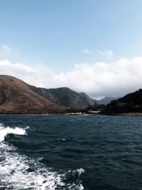 Scenic view of sea and mountains against sky