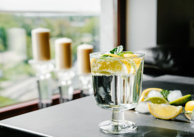 Refreshing iced infused water with lime, lemon and mint on dark background. 