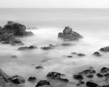 Scenic view of rocks in sea against sky